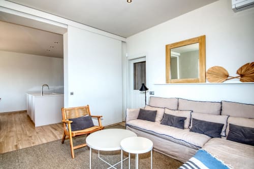Modern studio apartment at Finques Garcia Enrich in Palafrugell with kitchenette, sofa, and wooden furnishings