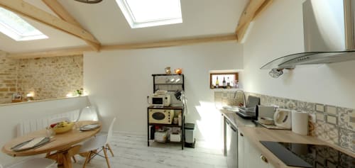 Bright modern kitchen at Aux Prés Du Berry B&B in Chavin, France, featuring skylights, wooden beams, and contemporary