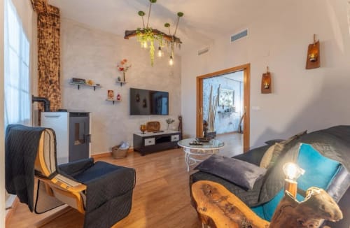 Sala moderna de casa en Mérida con vista a piscina, muebles oscuros, detalles de madera y decoración contemporánea