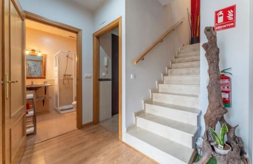 Pasillo de la cabaña con baño, escaleras y planta decorativa en el hotel Gestyp-AT de Mérida
