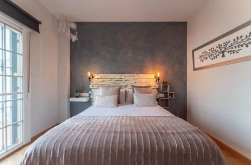 Dormitorio de cabaña moderna en Gestyp-AT, Mérida, con cabecero de madera rústica, iluminación cálida y decoración elegante