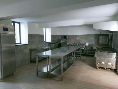 Cuisine professionnelle du Château de Baylac équipée de tables inox, réfrigérateurs et matériel de cuisson à Bugnein