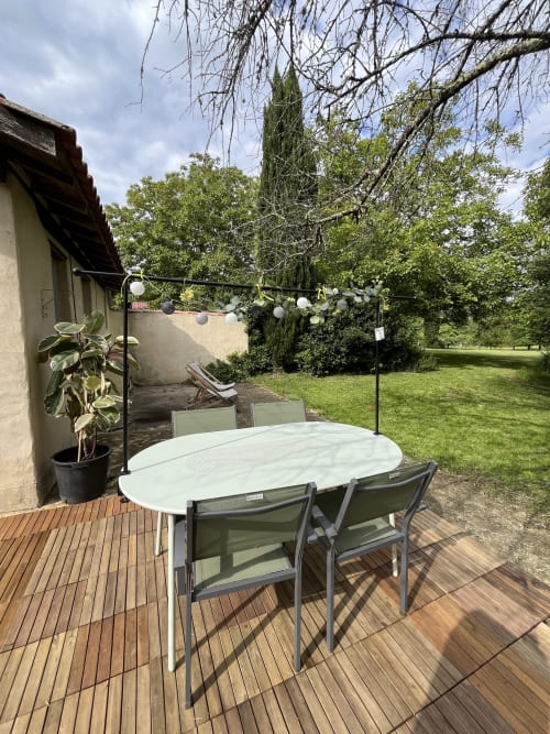 Terrasse extérieure des Papillons de Baccara à Gondrin avec table de dîner et vue sur le jardin