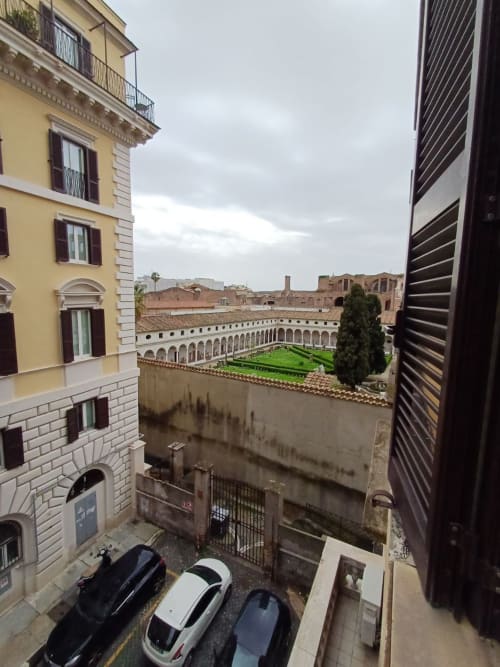 Camera matrimoniale con letto king presso Michelangelo Suite Roma affaccia su un suggestivo chiostro storico con giardino verde a Roma