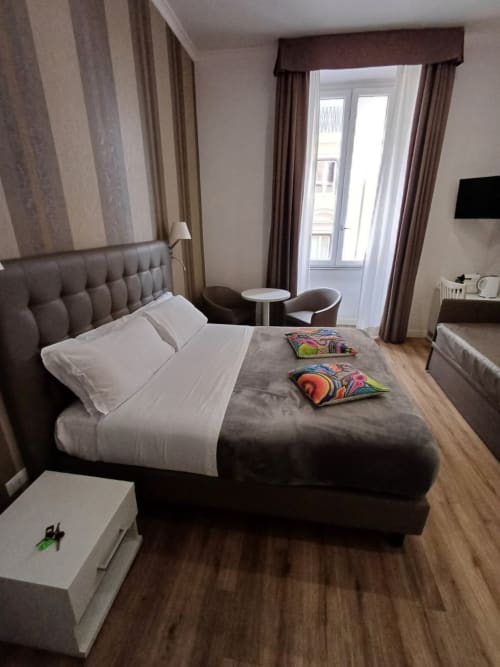 Suite Michelangelo Roma, camera con letto king size, testata a righe, balcone sulla veranda, servizi moderni