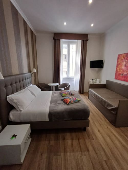 Camera moderna della Michelangelo Suite Roma con letto king, zona living, porte con balcone e vista sul giardino