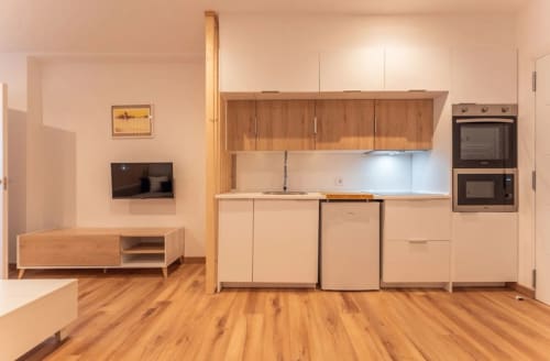 Cocina y sala modernas con muebles de madera, electrodomésticos de acero inoxidable y piso de madera en Mérida