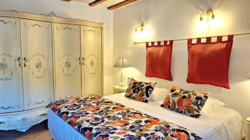 Chambre Sheepfold de La Bergerie Du Moulin à Taradeau, avec armoire ornementale, literie colorée et rideaux rouges