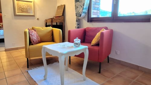 Coin salon confortable de la Suite Sheepfold à La Bergerie Du Moulin avec fauteuils jaunes et rouges, table basse blanche et