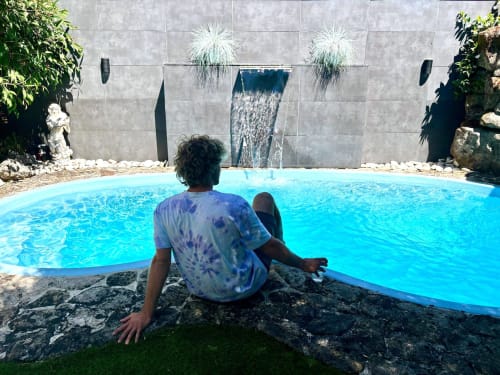 Huésped relajándose junto a la piscina privada de Serenidade en Baiona con pared de azulejos y plantas decorativas