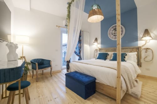 Camera moderna a Cuore di Rocca a Rocca di Papa con dettagli blu, letto a quattro colonne in legno e arredamento contemporaneo