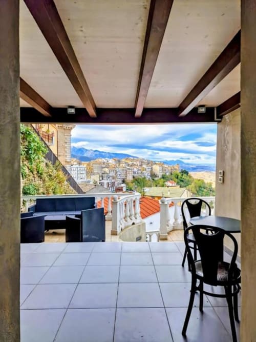 Terrazza Tales of Abruzzo con vista montagna, sedia nera, travi in legno e panorama di Atessa