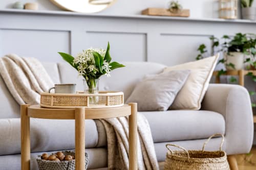 Accogliente salotto a Tales of Abruzzo con divano bianco, tavolino in legno, fiori bianchi freschi e arredamento neutro ad Atessa