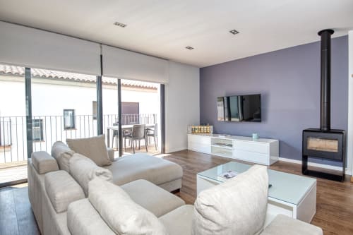 Modern apartment living room in Palafrugell with beige sectional, fireplace, TV, and terrace access