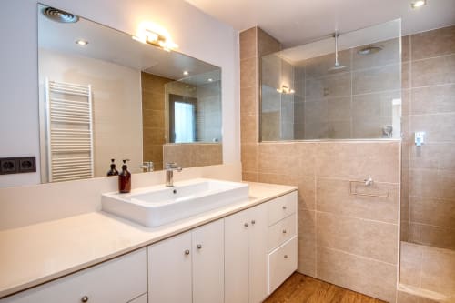 Modern bathroom with white vanity, vessel sink, and glass shower enclosure in Calella apartment