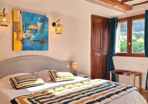 Chambre de style champêtre à La Bergerie Du Moulin à Taradeau avec literie rayée, mobilier en bois et décoration bleue.