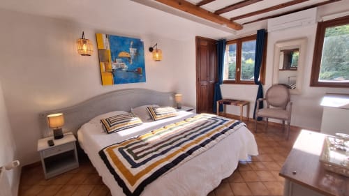 Chambre de style campagnard à La Bergerie Du Moulin à Taradeau avec lit queen-size, literie rayée, poutres apparentes et accents bleus