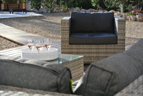 Mobilier de détente contemporain à CARPE DIEM Résidence Hôtelière à Lorgues : fauteuil tressé, verres de vin et patio en graviers