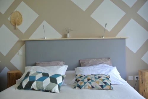 Chambre moderne à la Résidence Hôtelière CARPE DIEM à Lorgues avec art mural géométrique et coussins à motifs