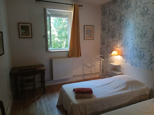 Chambre douillette au Domaine de Lamartine à Pont-Saint-Esprit avec vue sur le jardin, lit, bureau et papier peint floral