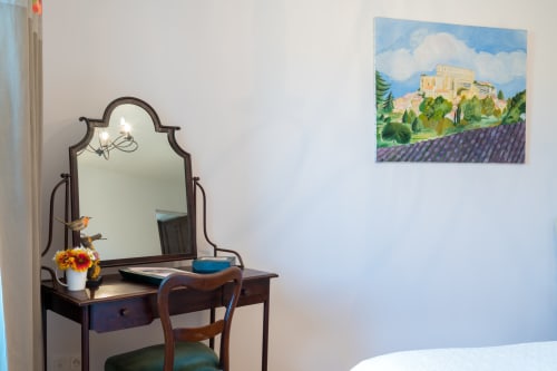 Bedroom vanity at L'Amiradou B&B in Félines-sur-Rimandoule with mirror, flowers, and Provence landscape painting