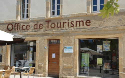 Devanture de l'Office de Tourisme à Bugnein, France près du Château de Baylac, façade en pierre et fenêtres bleues