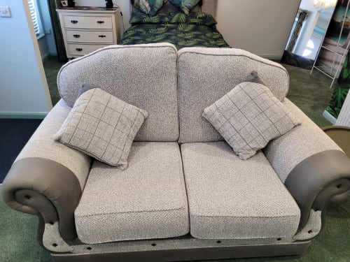Beige upholstered loveseat with rolled arms and plaid cushions in Jane's B&B apartment, Guisborough