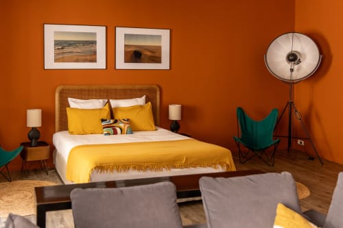Bright orange bedroom with yellow bedding, wicker headboard, and modern furnishings at Le Prieuré Notre-Dame