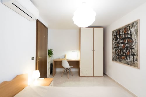 Camera moderna di Le Arche, Verona con guardaroba, scrivania, sedia e arte contemporanea alle pareti