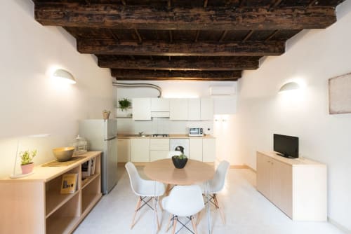 Cucina e zona pranzo moderne a Le Arche a Verona con travi in legno e arredi contemporanei