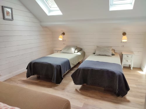 Der Komfort des 2. Zimmers im Pavillon mit zwei Einzelbetten, Leselampen und Steckdose auf Augenhöhe