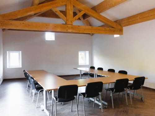 Modern meeting room at L'Amiradou B&B in Félines-sur-Rimandoule with wooden beams and U-shaped table setup