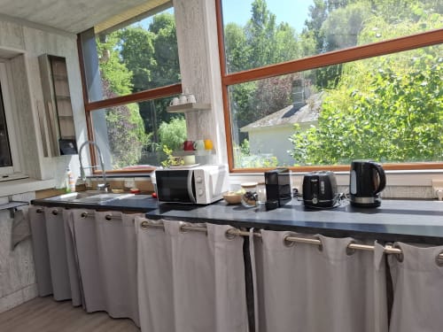 Kitchenette moderne à Accolade Châteaudun avec vue sur la rivière, micro-ondes, bouilloire et appareils électroménagers
