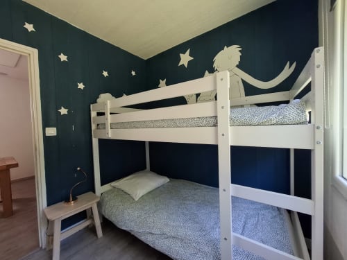 Lit superposé enfant avec structure blanche au gîte Accolade, Châteaudun, murs bleu-canard avec décoration d'étoiles.