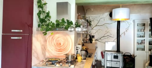 Modern kitchen in CasaRosada Vidracco with burgundy refrigerator, gas cooktop, pendant lamp, and potted plants in wellness