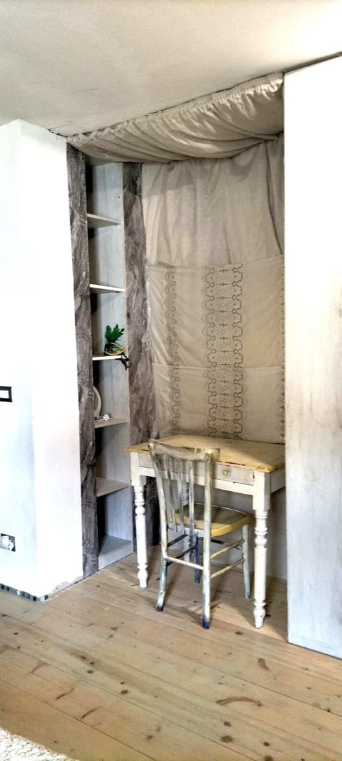 Cozy workspace nook at CasaRosada Wellness Retreat in Vidracco with desk, chair, shelving, and draped fabric canopy