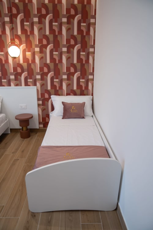 Modern bedroom at Ruah Pompei Pompeii B&B with single bed, red patterned wallpaper, and wooden flooring