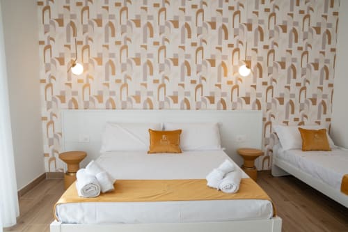Ruah Pompei triple room with geometric patterned wallpaper, white beds, wooden accents, and pendant lighting