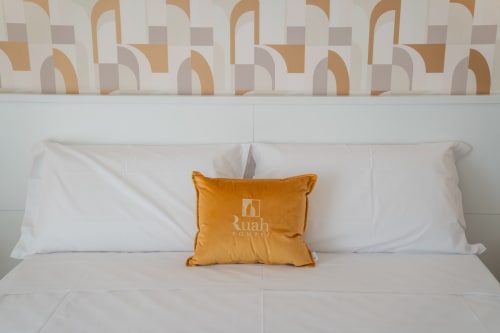 Letto Ruah Pompei con cuscini bianchi e federa dorata, testata decorativa, camera tripla gialla in B&B a Pompei, Italia
