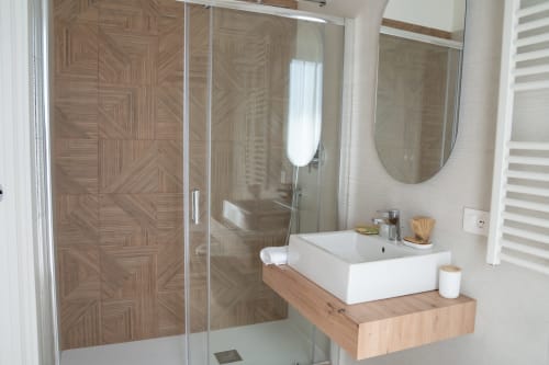 Modern bathroom at Ruah Pompei B&B in Pompei with wooden shower, white sink, and elegant tilework