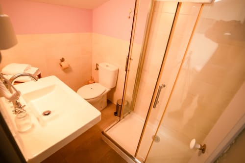 Salle de bain moderne avec lavabo blanc, toilettes et douche vitrée à la Casa Rural La Perla, Hiendelaencina