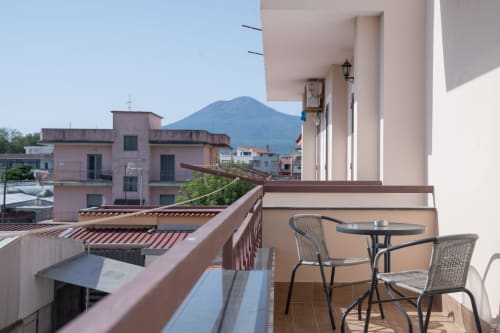 Balcony at Ruah Pompei with Mount Vesuvius view, wicker chairs, table in Pompeii