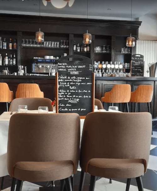 Intérieur moderne de café à Home Horizon à Limoges avec chaises marron, comptoir noir et luminaires suspendus