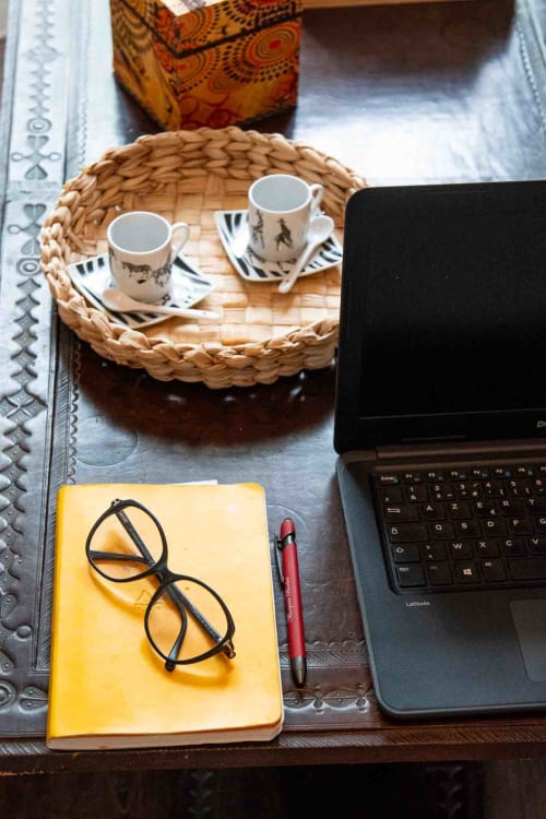 Bureau cosy avec ordinateur, carnet et café, maison d’hôtes à Evry, France, Essonne, ambiance studieuse, chaleureuse, confortable.