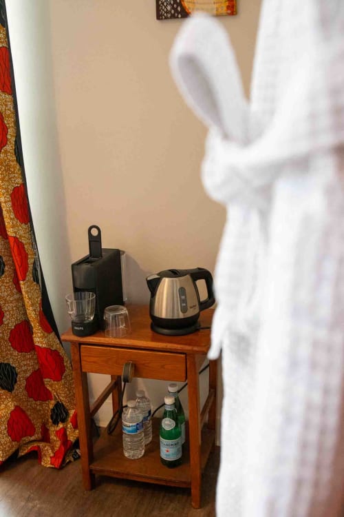 Coin boissons avec bouilloire et peignoir, chambre maison d’hôtes à Evry, France, Essonne, confort pratique, accueil soigné, détente.