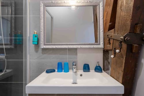 Salle de bain moderne avec lavabo élégant, miroir raffiné, maison d’hôtes à Evry, Essonne, France, propreté, confort, ambiance apaisante
