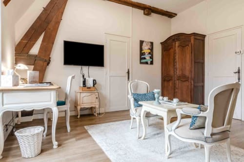 Salon élégant avec poutres apparentes, coin détente lumineux, chambre maison d’hôtes à Evry, Essonne, France, charme, confort, accueil chaleureux.