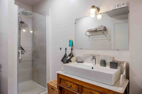 Salle de bain lumineuse avec douche et meuble bois vintage, maison d’hôtes à Evry, Essonne, France, propreté, confort, ambiance apaisante