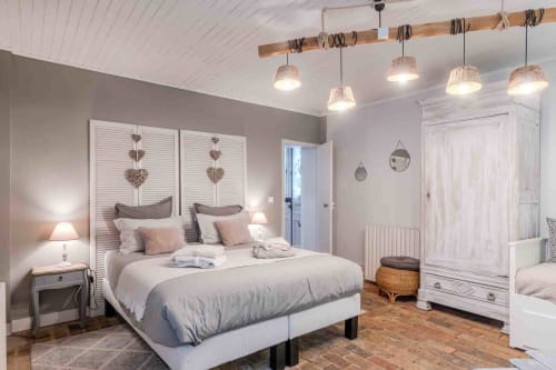 Chambre spacieuse avec lit central, suspensions chaleureuses, maison d’hôtes à Evry, Essonne, France, charme, confort, ambiance accueillante, couleurs douces