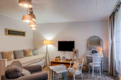 chambre au rez de chaussée cosy avec banquette lit, coin bureau et luminaires, maison d’hôtes à Evry, Essonne, France, charme, confort, ambiance chaleureuse.